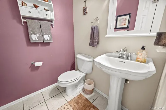 a bed sitting in a bedroom next to a window with a lamp and a rug