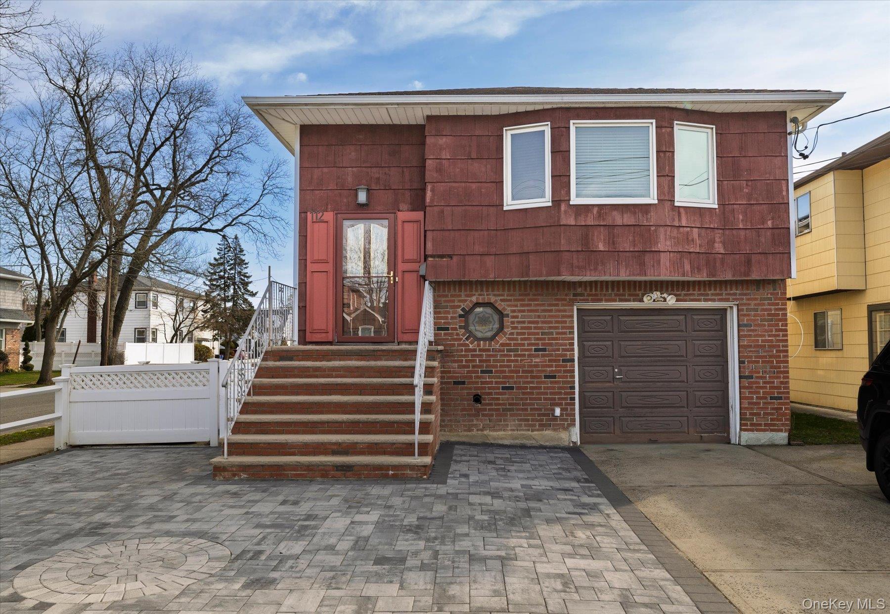 112 Chestnut Street Lynbrook, NY 11563 - Photo 1 of 13 a front view of a house with a yard and garage