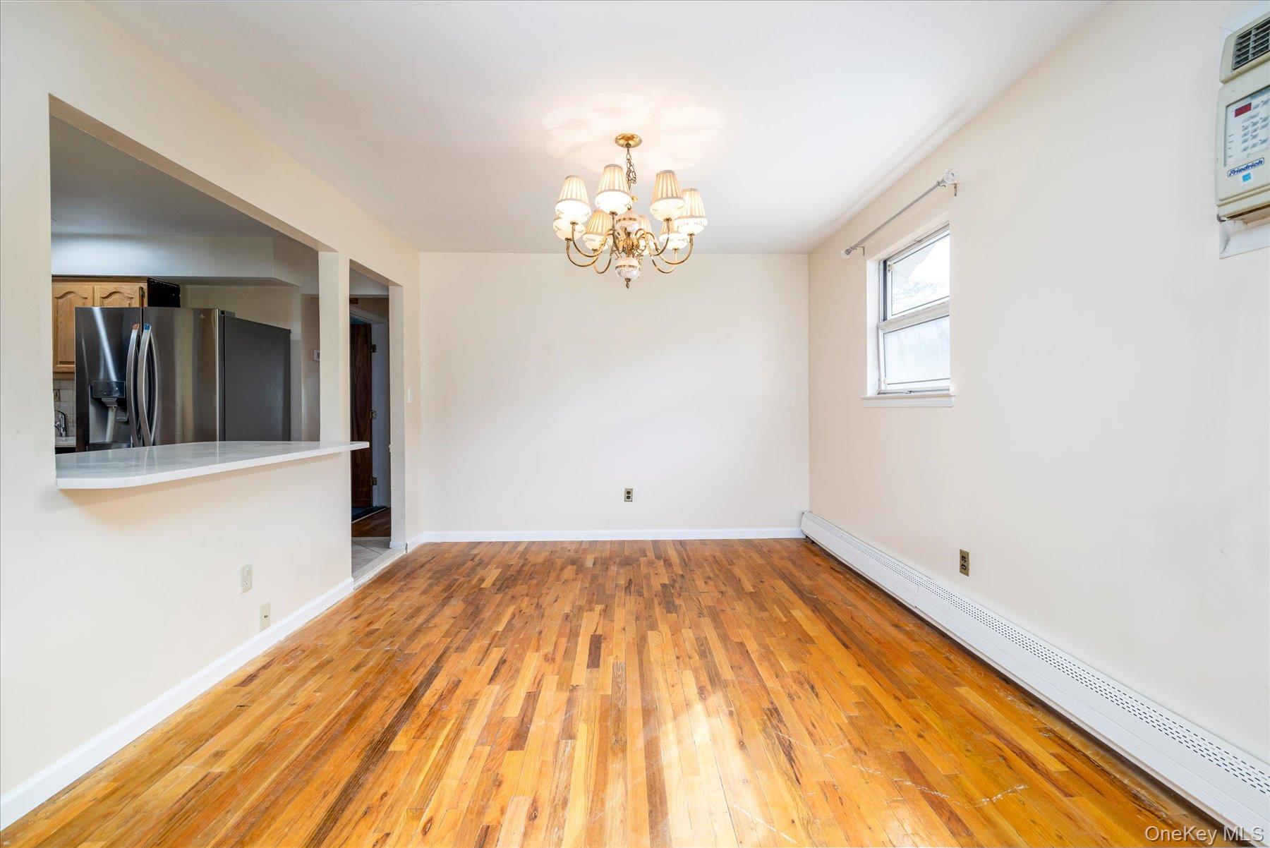 112 Chestnut Street Lynbrook, NY 11563 - Photo 5 of 13 a view of a room with wooden floor and chandelier