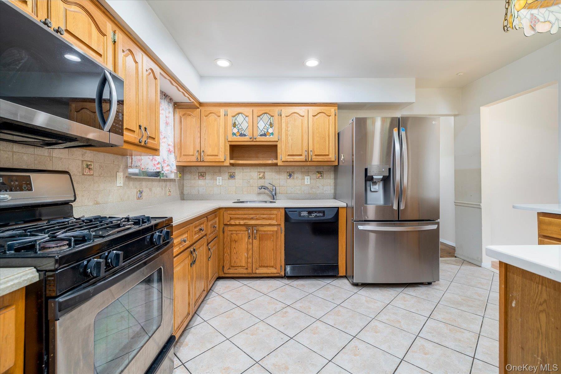 112 Chestnut Street Lynbrook, NY 11563 - Photo 7 of 13 a kitchen with stainless steel appliances granite countertop a stove a sink and a refrigerator