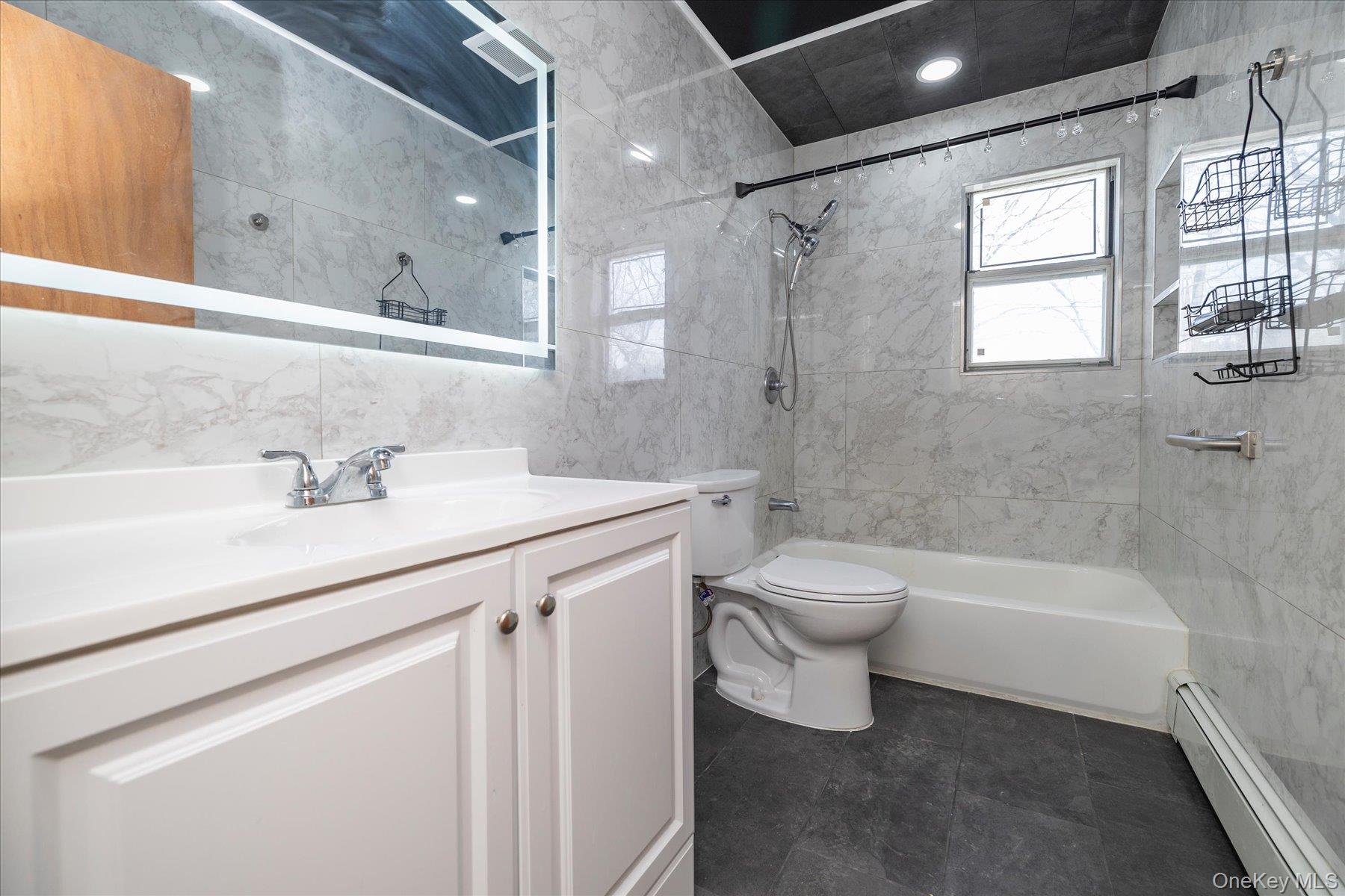 112 Chestnut Street Lynbrook, NY 11563 - Photo 9 of 13 a bathroom with a sink a toilet and a bathtub