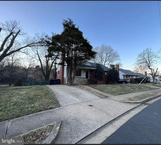 a front view of a house with a yard and trees