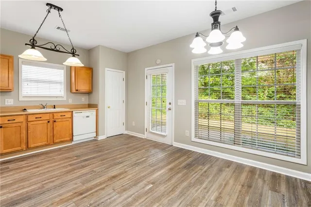 a view of a kitchen with wooden floor and a window