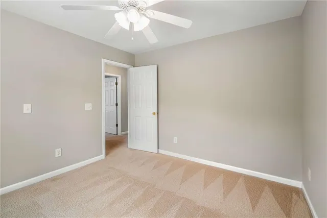 an empty room with a ceiling fan and a window