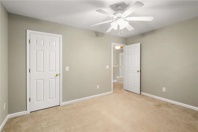 an empty room with closet and a chandelier fan