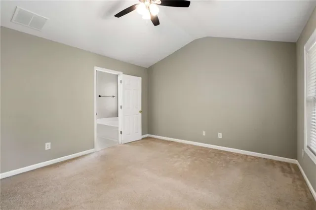 an empty room with a ceiling fan and window