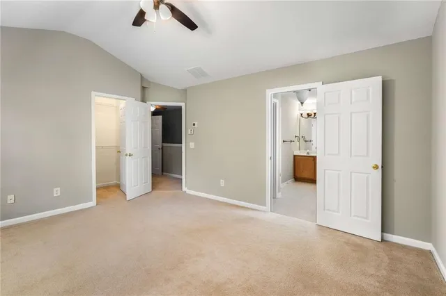 an empty room with closet and a ceiling fan