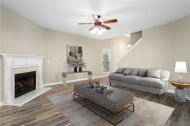 a living room with furniture a fireplace and a ceiling fan