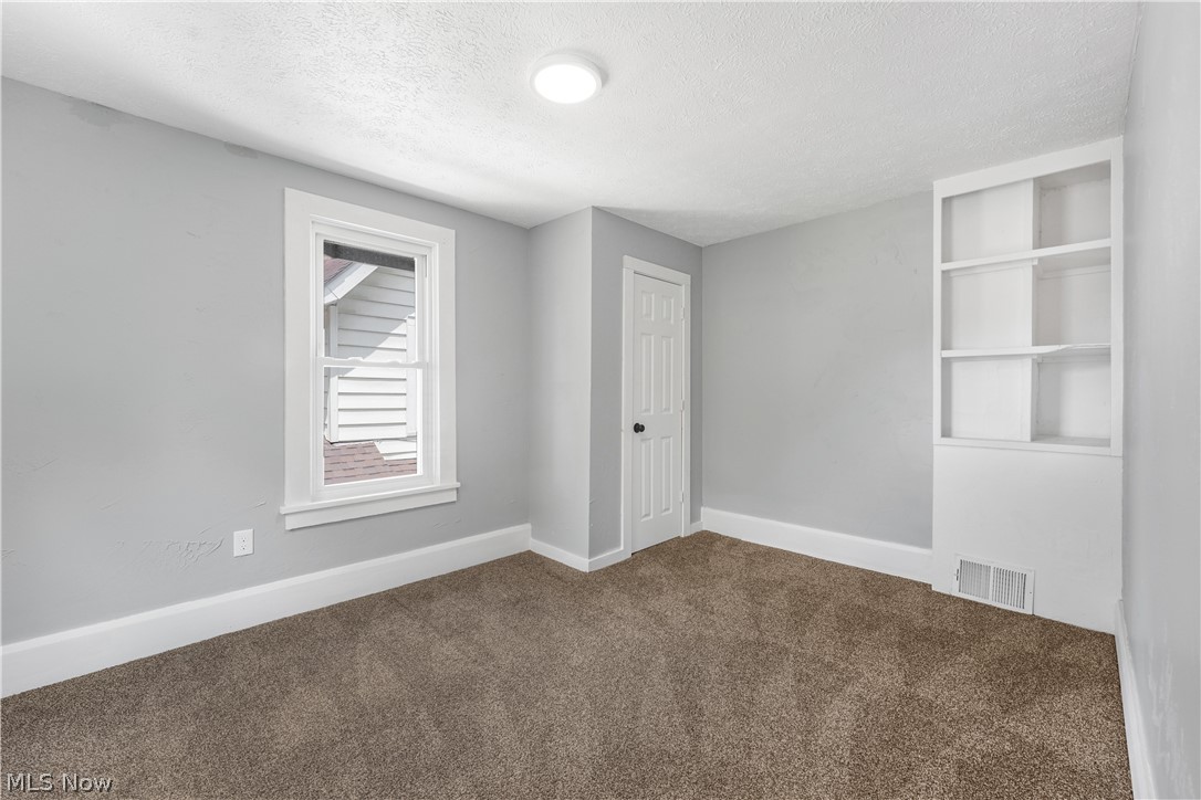 885 Wales Road Northeast Massillon, OH 44646 - Photo 19 of 34 Room featuring neutral gray wall paint, brown carpet flooring, and white trim