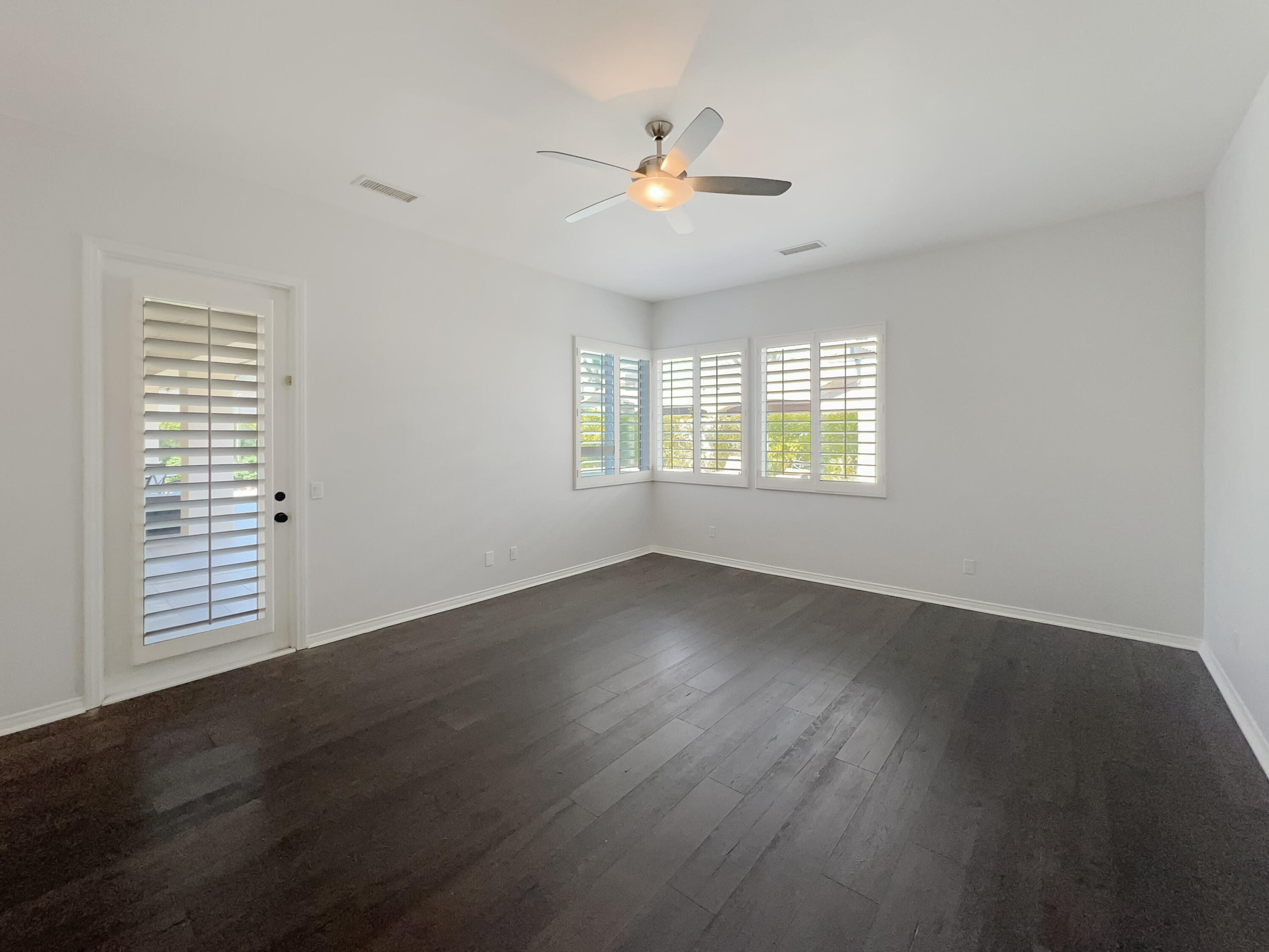 5 Lyon Road Rancho Mirage, CA 92270 - Photo 12 of 36 an empty room with wooden floor and windows