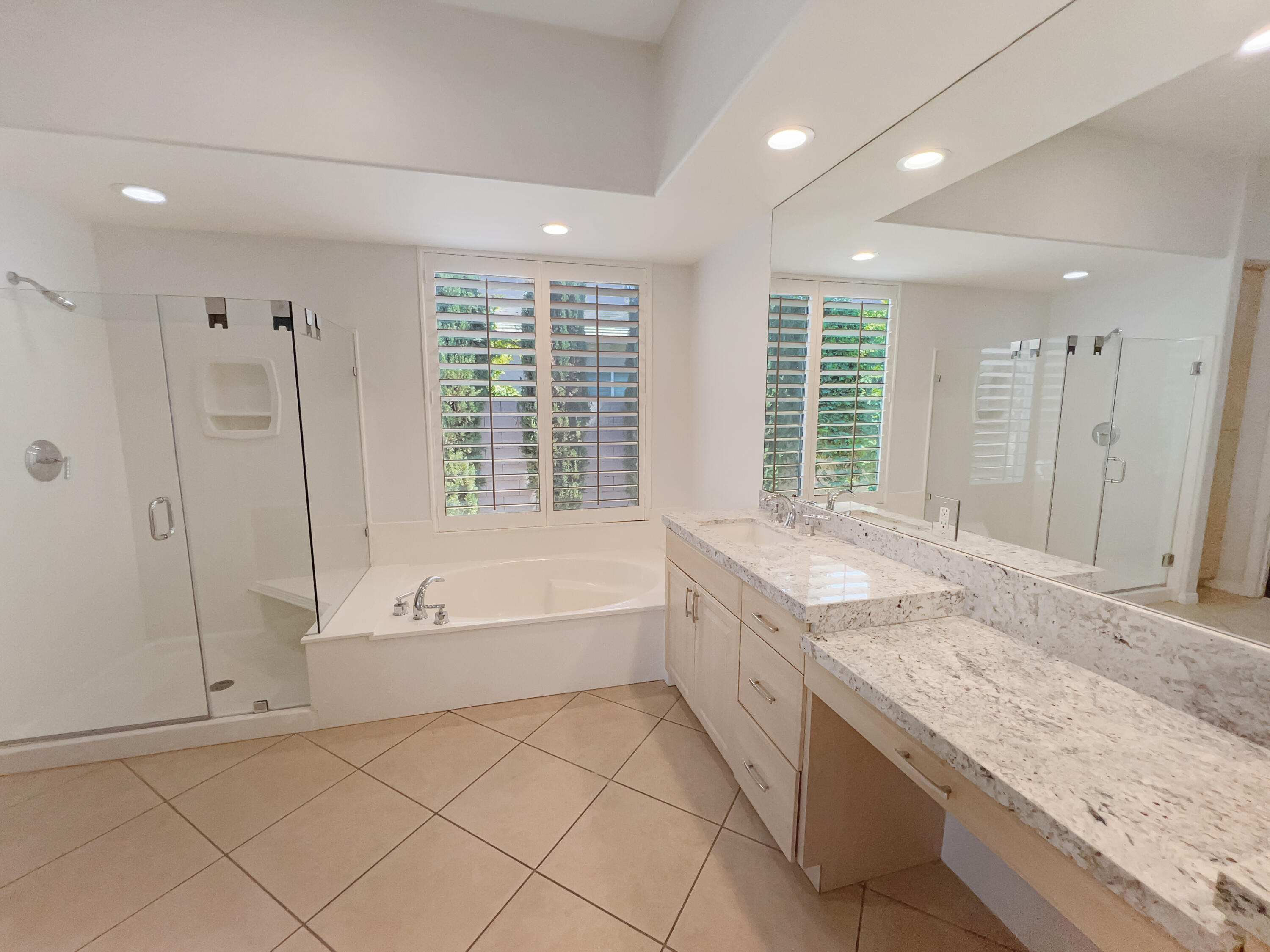 5 Lyon Road Rancho Mirage, CA 92270 - Photo 15 of 36 a spacious bathroom with a granite countertop tub sink and mirror