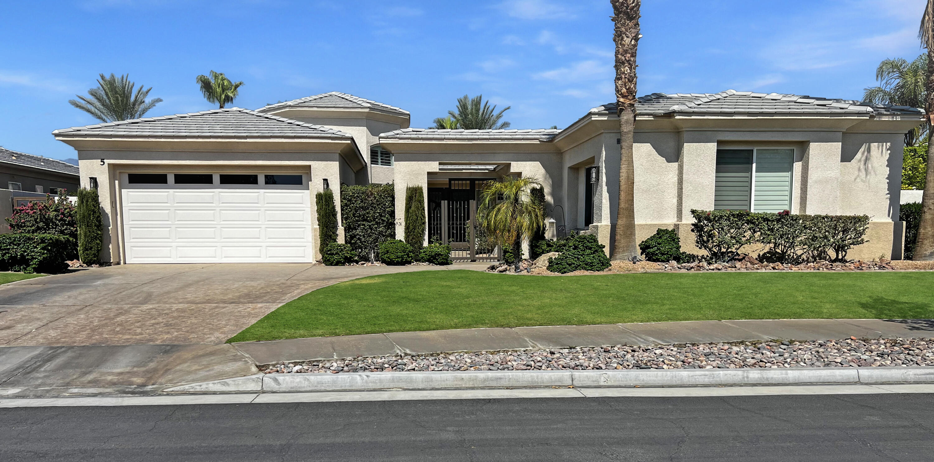 5 Lyon Road Rancho Mirage, CA 92270 - Photo 2 of 36 a front view of a house with a garden