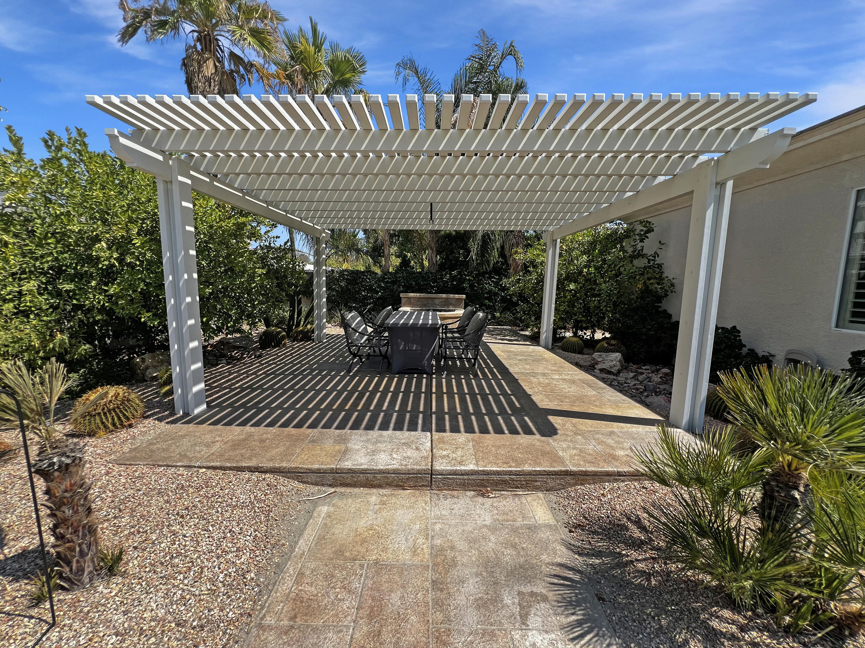 5 Lyon Road Rancho Mirage, CA 92270 - Photo 27 of 36 a patio with table and chairs and potted plants