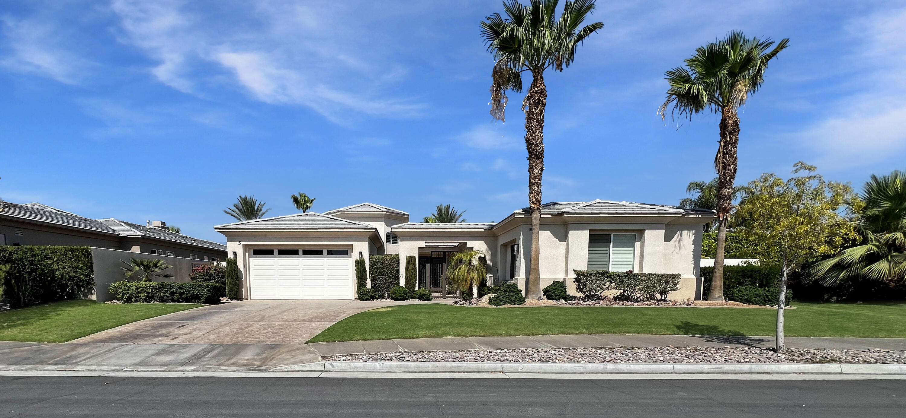 5 Lyon Road Rancho Mirage, CA 92270 - Photo 33 of 36 a front view of a house with a garden and trees