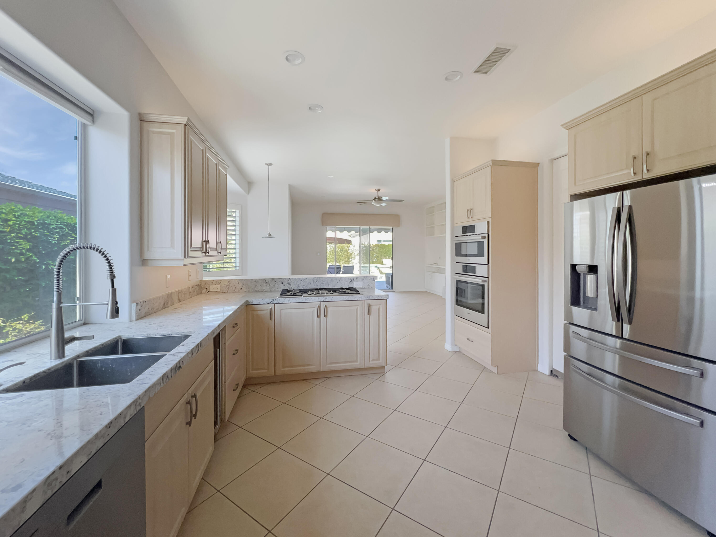 5 Lyon Road Rancho Mirage, CA 92270 - Photo 10 of 36 a kitchen with a refrigerator sink and cabinets