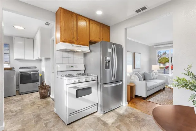 a kitchen with stainless steel appliances granite countertop a stove a refrigerator and a refrigerator