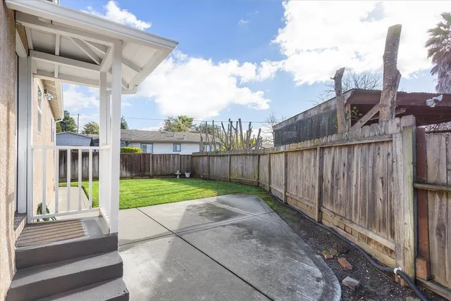 a view of a backyard with wooden fence