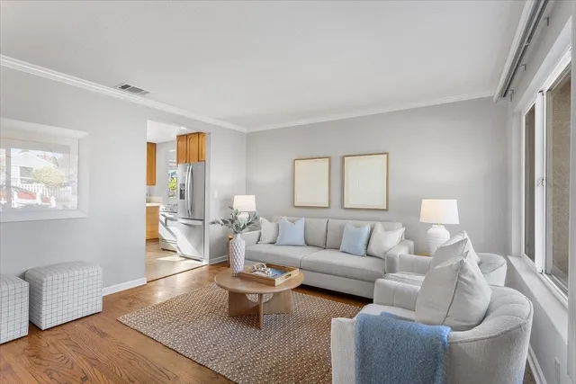 a living room with furniture and a wooden floor