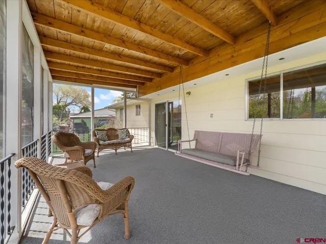 a view of a patio with table and chairs and wooden floor