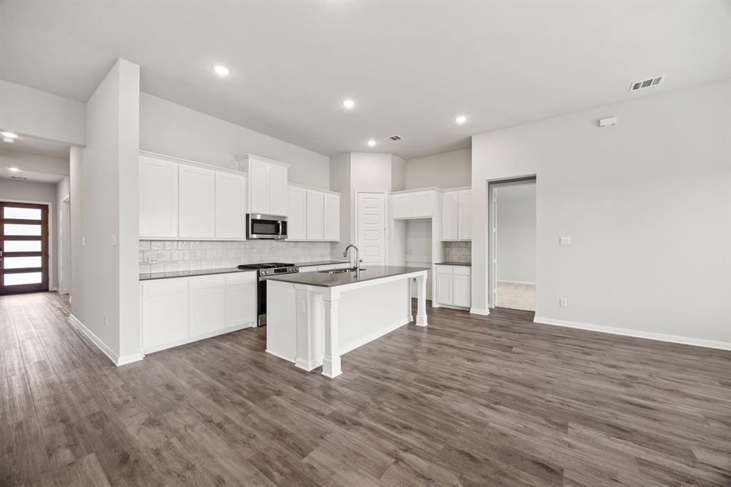 1506 Red Clover Avenue Van Alstyne, TX 75495 - Photo 7 of 24 a kitchen with white cabinets and stainless steel appliances