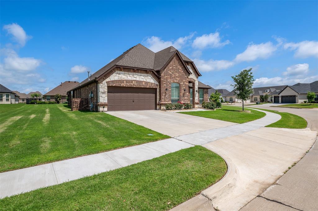 2011 Spieth Street Granbury, TX 76048 - Photo 25 of 35 French provincial home with a residential view, brick siding, driveway, a front lawn, and a garage