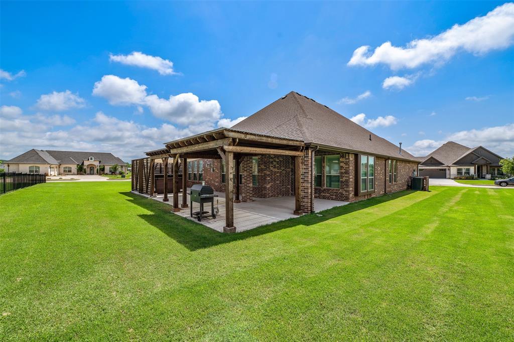 2011 Spieth Street Granbury, TX 76048 - Photo 26 of 35 Rear view of property with brick siding, a patio, and roof with shingles