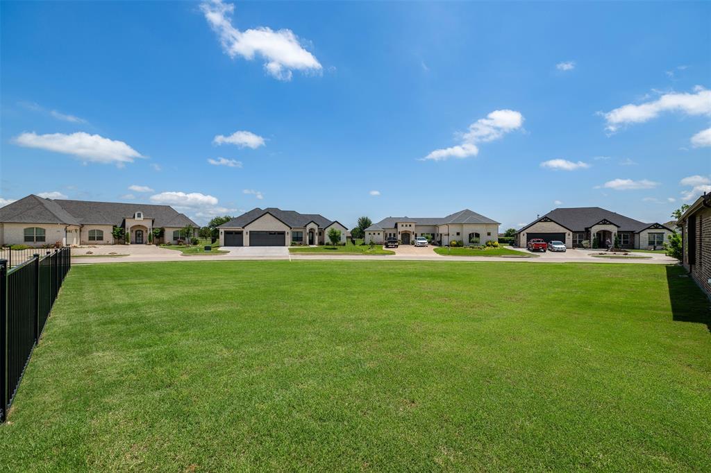 2011 Spieth Street Granbury, TX 76048 - Photo 30 of 35 View of yard featuring a residential view, a garage, and driveway
