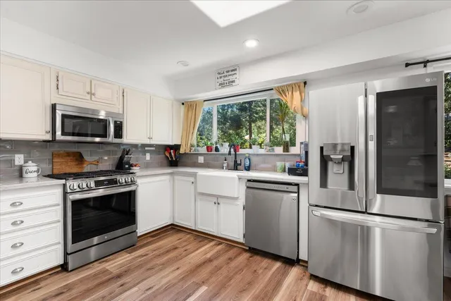 a kitchen with stainless steel appliances granite countertop a stove a sink and a refrigerator