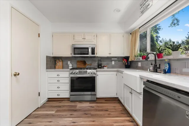 a kitchen with stainless steel appliances a stove microwave and cabinets
