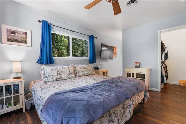 a bedroom with a bed and wooden floor