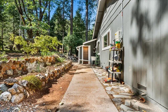 a backyard of a house with large trees and outdoor seating