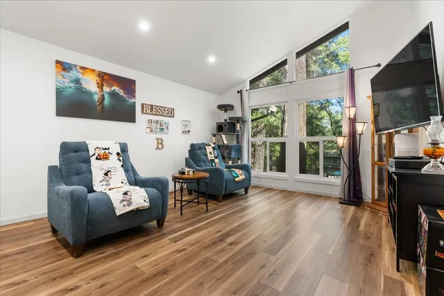 a living room with furniture wooden floor and a flat screen tv
