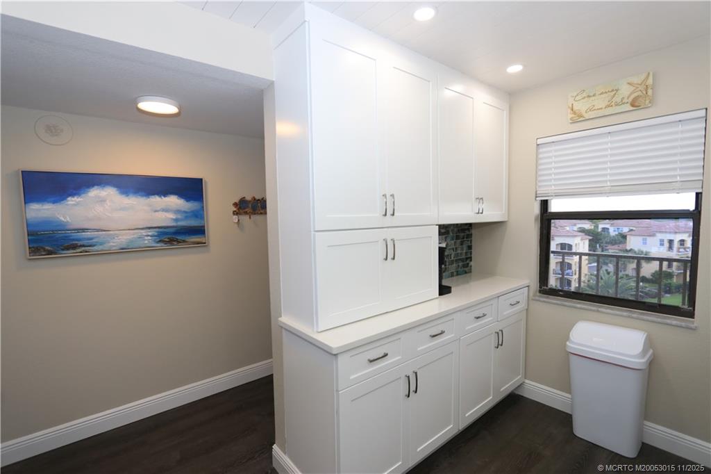 7380 South Ocean Drive, Unit 621 Jensen Beach, FL 34957 - Photo 6 of 48 a hallway with white cabinets and white appliances
