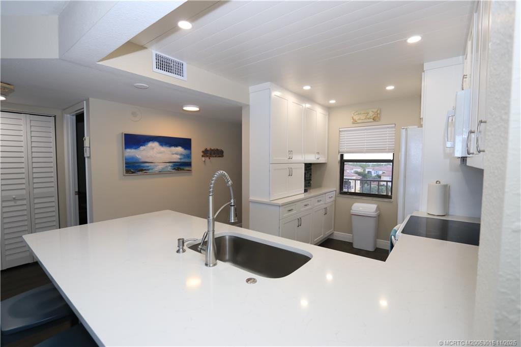 7380 South Ocean Drive, Unit 621 Jensen Beach, FL 34957 - Photo 8 of 48 a kitchen with stainless steel appliances a sink and a refrigerator