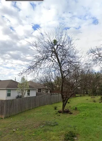 a view of a backyard with large trees