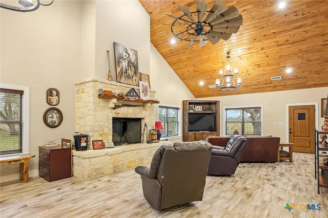a living room with furniture a fireplace and a chandelier
