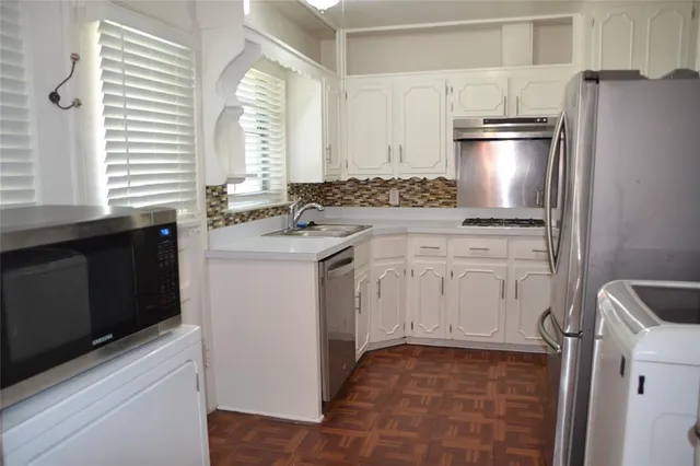 a kitchen with white cabinets and white appliances