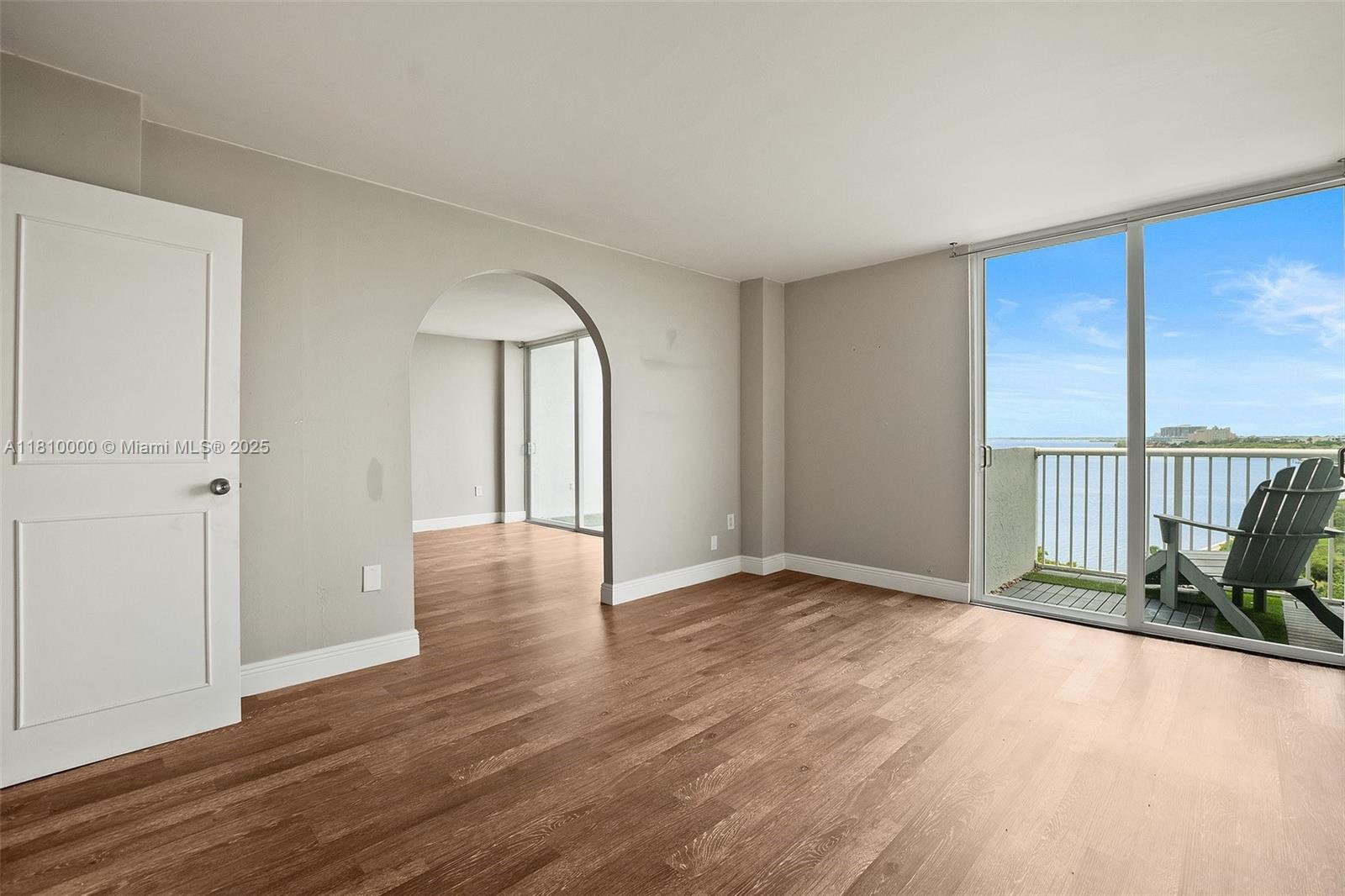 a view of a room with wooden floor and glass door