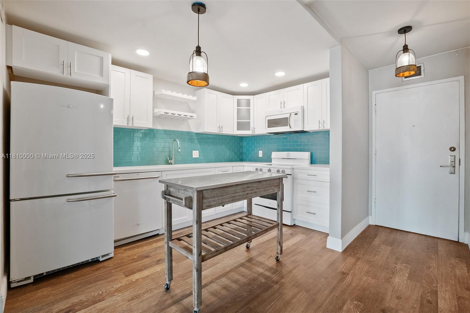 150 Southeast 25th Road, Unit 10K Miami, FL 33129 - Photo 7 of 43 a kitchen with kitchen island a wooden floor and refrigerator