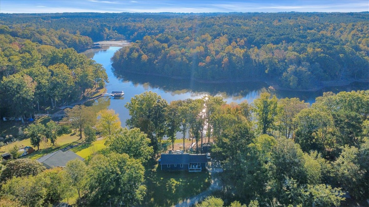 122 Latham Drive Anderson, SC 29621 - Photo 32 of 40 This elevated view highlights a lakeside residence, nestled among lush trees, offering a private dock.