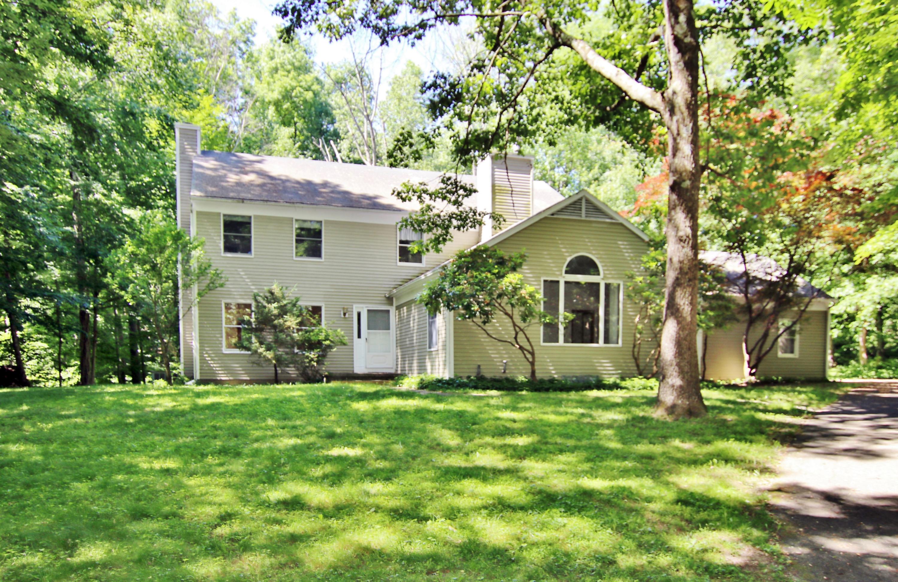 a front view of house with yard and green space