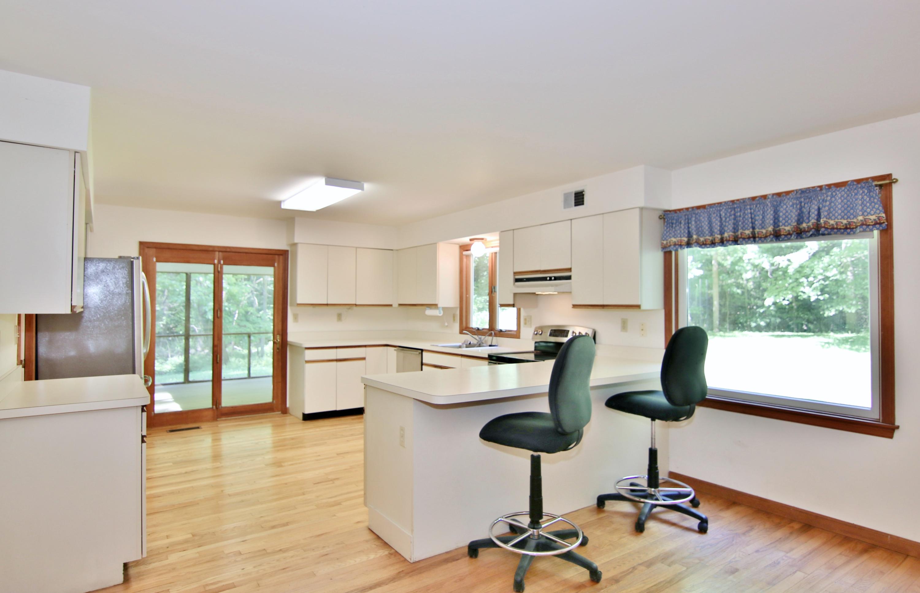 838 Valley Road New Canaan, CT 06840 - Photo 14 of 44 a kitchen with kitchen island a stove a table and chairs in it