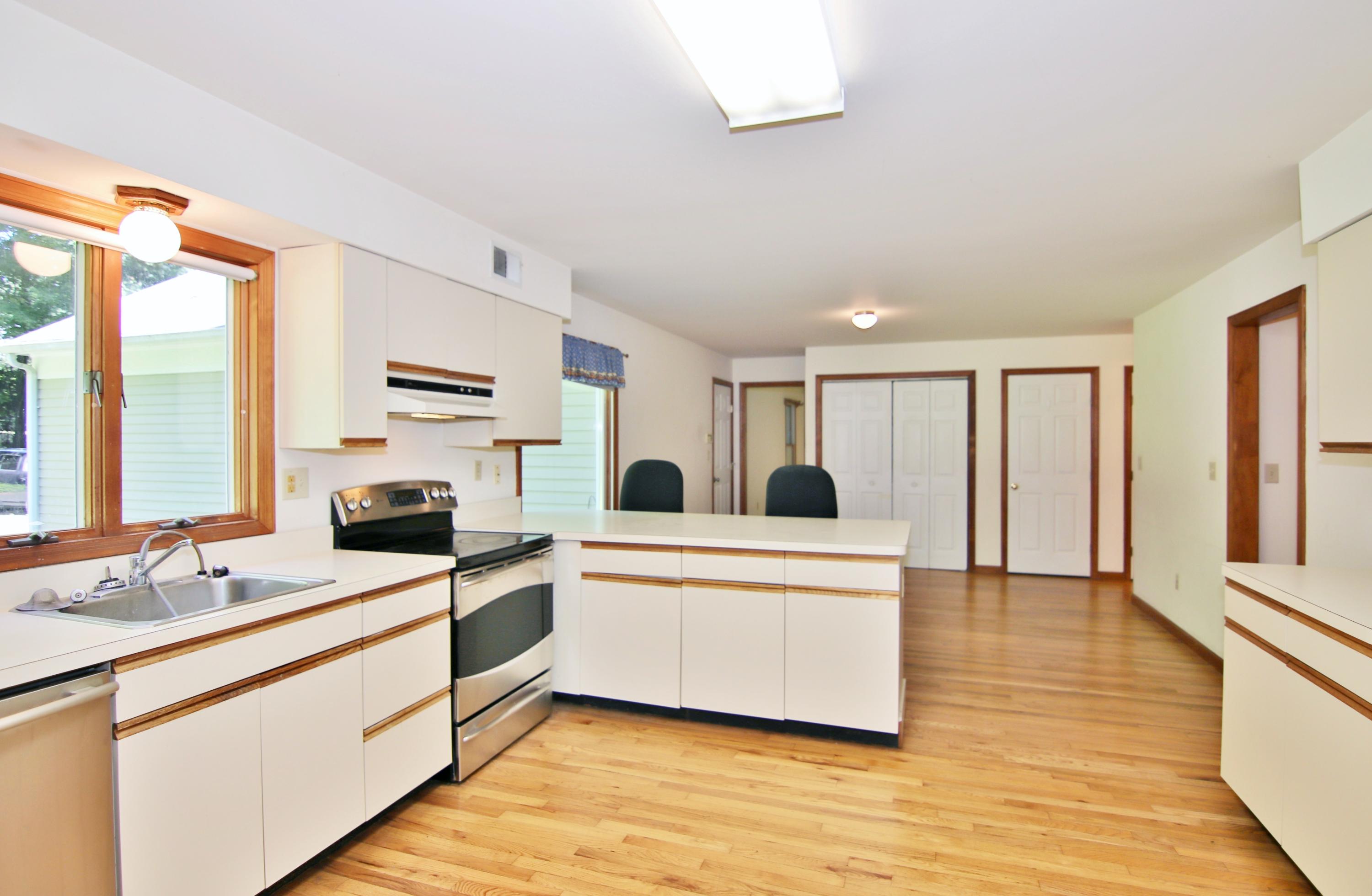 838 Valley Road New Canaan, CT 06840 - Photo 16 of 44 a large white kitchen with cabinets a sink a window and a refrigerator