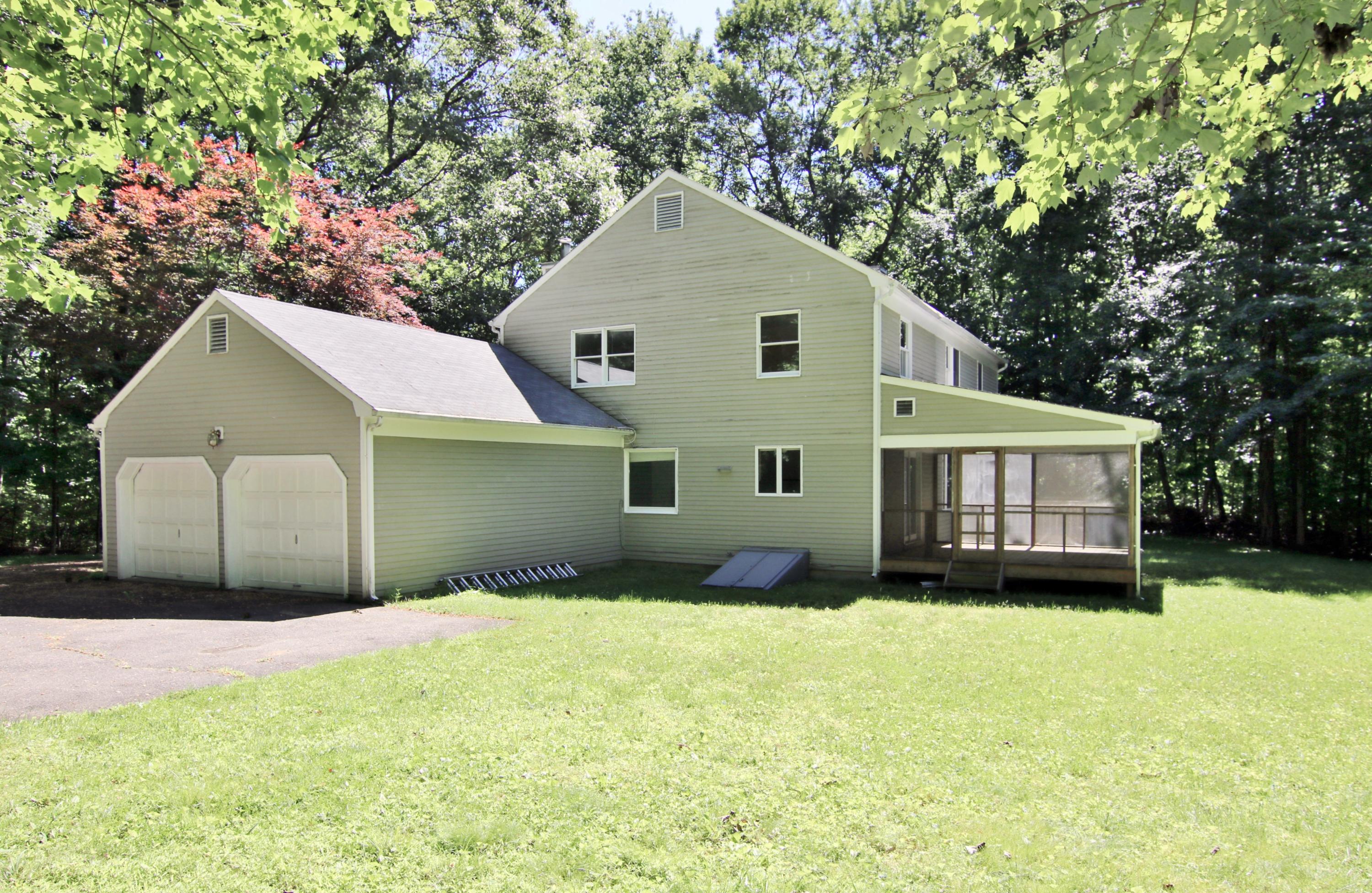 838 Valley Road New Canaan, CT 06840 - Photo 40 of 44 a front view of a house with a yard and garage