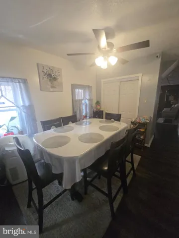 a view of a dining room with furniture and a chandelier fan