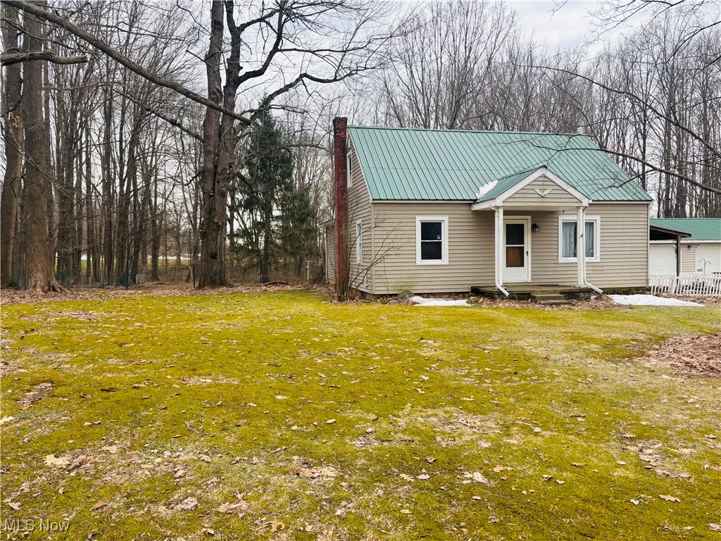 685 Furnace Road Conneaut, OH 44030 - Photo 3 of 22 View of front of house featuring metal roof, a chimney, and a front yard