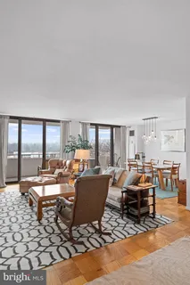 a living room with furniture large window and a table