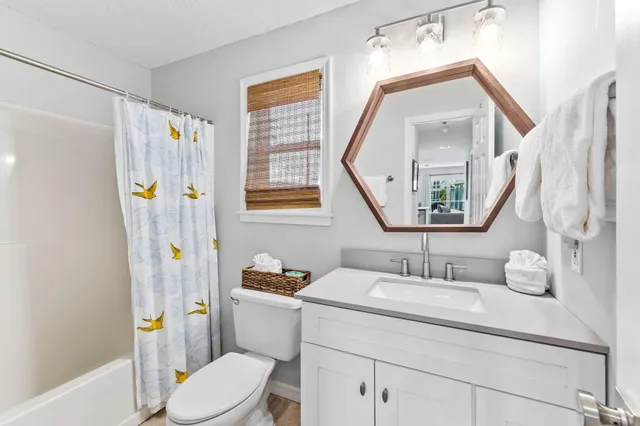 a bathroom with a sink vanity mirror and toilet