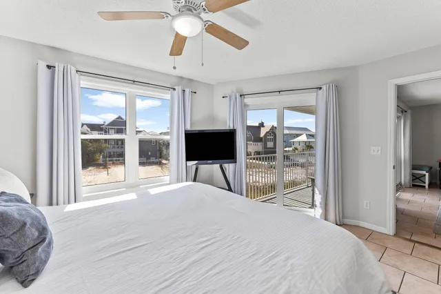 a bedroom with a large bed and a flat tv screen next to a window