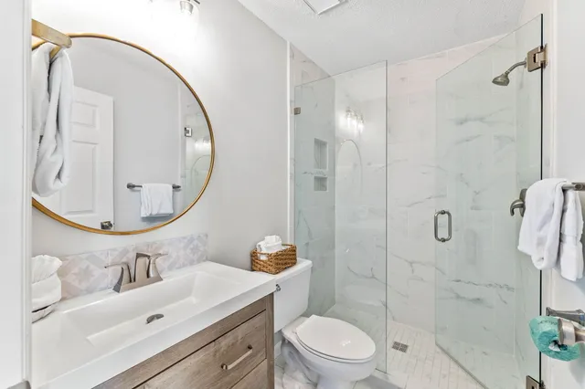 a bathroom with a sink a toilet and shower